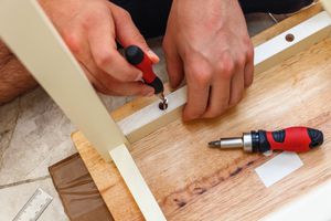 Person screwing together parts of a table
